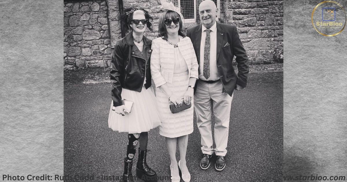 Ruth Codd in a white dress and black jacket with her father and mother