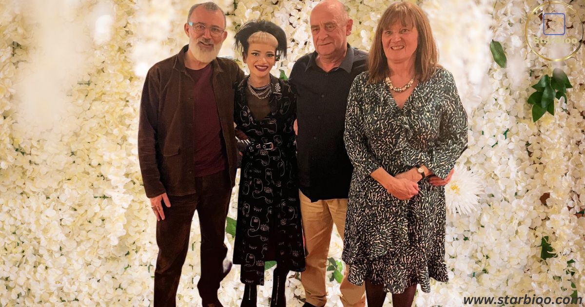 Ruth Codd in a black dress with silver check on it with her father and mother